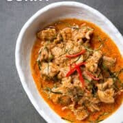 A plate of panang curry with text overlay "Thai Panang Curry" and "Hotthaikitchen.com"
