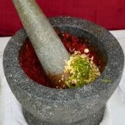 curry paste ingredients in a mortar and pestle.
