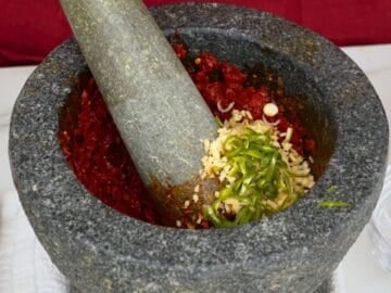 curry paste ingredients in a mortar and pestle.