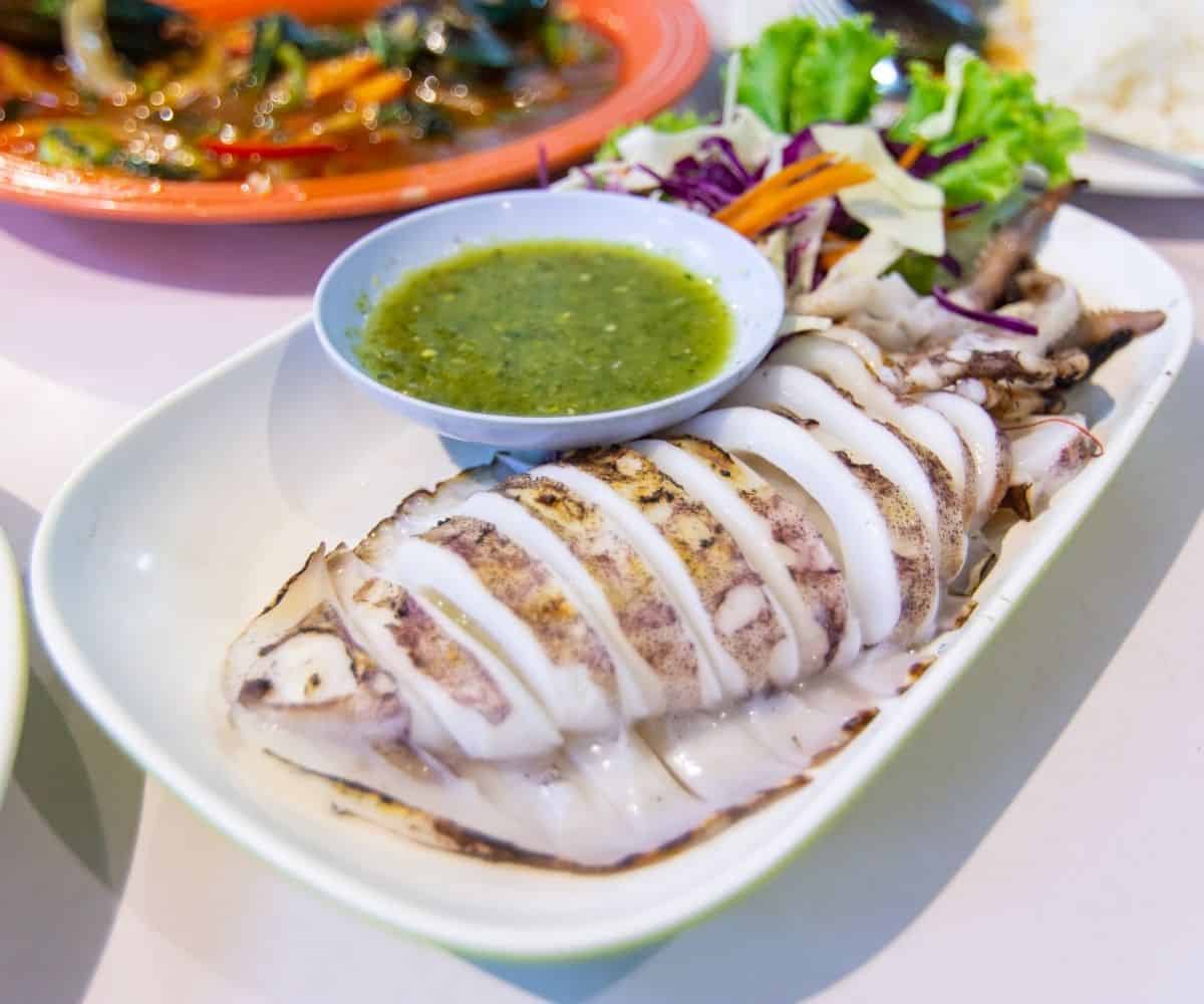 grilled squid sliced and a bowl of nam jim seafood