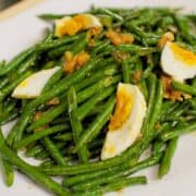 a plate of long bean stir fry with salted duck eggs