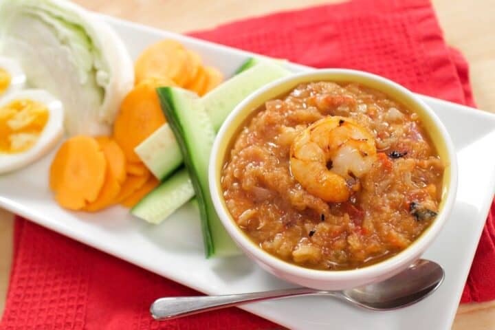 A bowl of Thai shrimp dip with a side of veggies and boiled eggs