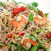 A plate of instant noodle salad with shrimp, tomatoes, and Chinese celery
