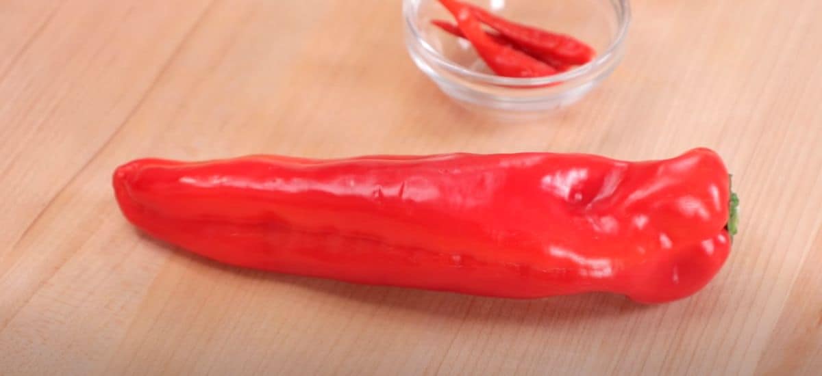 a long red pepper with 3 thai chilies in the back