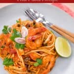 a plate of tom yum spaghetti with shrimp and a wedge of lime with text overlay "tom yum spaghetti Thai pasta recipe" and "hotthaikitchen.com"