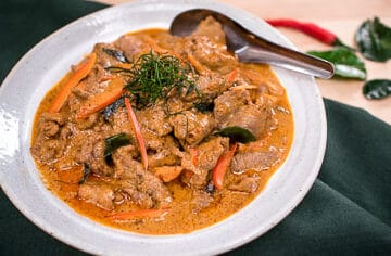 Panang is a popular classic Thai curry with a rich and luscious peanut sauce over tender beef that is super quick to make. I also share how to make semi-homemade panang curry paste using store-bought red curry paste as a base. An easy, delicious, gluten-free weeknight meal! #panangcurry #thaicurry #hotthaikitchen #Thairecipe #beefcurry