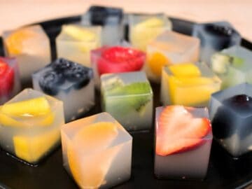 a plate of coconut water jelly cubes with fruit inside
