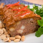 Massaman meatloaf on a plate with peanuts and cilantro garnish.