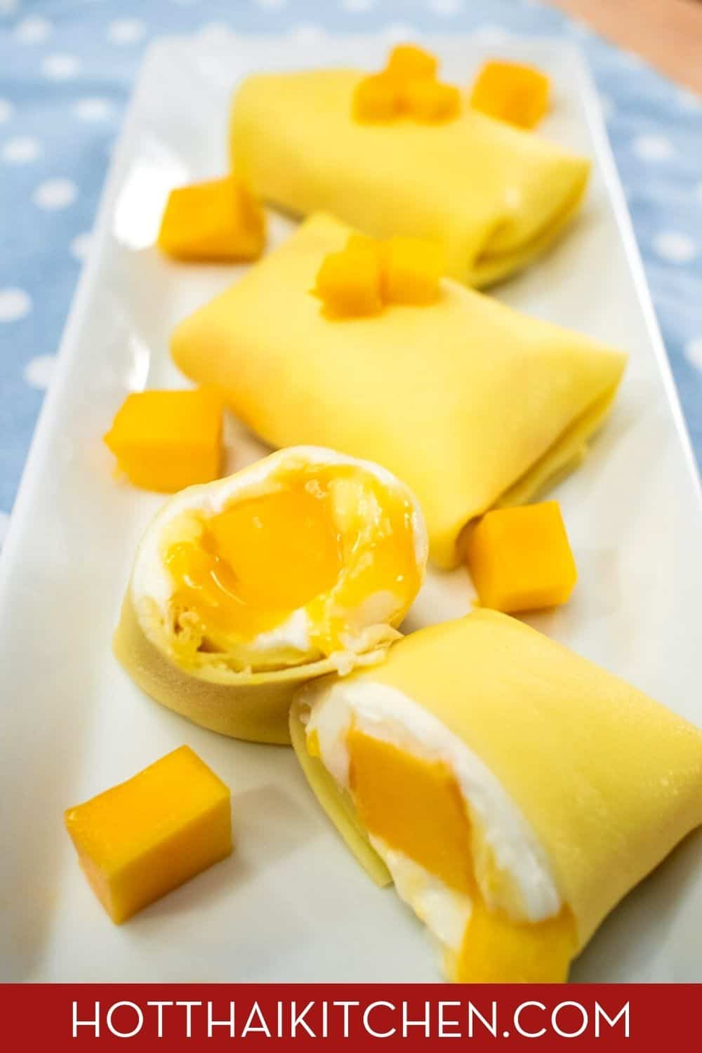 Pinterest friendly image of Hong Kong mango pancakes and mango cubes on a white plate. With hot-thai-kitchen.com text on the bottom.