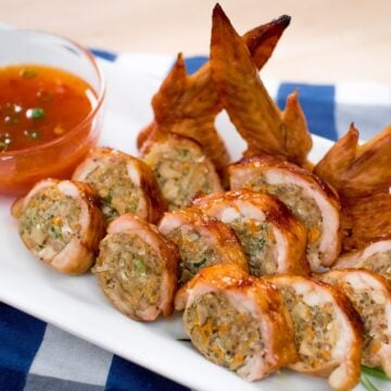 A plate of stuffed chicken wings with dipping sauce