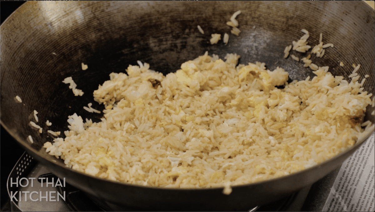 A wok with fried rice in it.