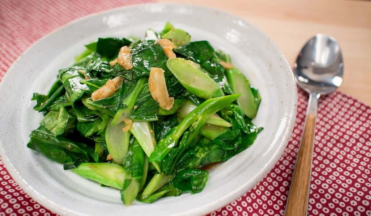 A plate of chinese broccoli stir fry with garlic pieces on top