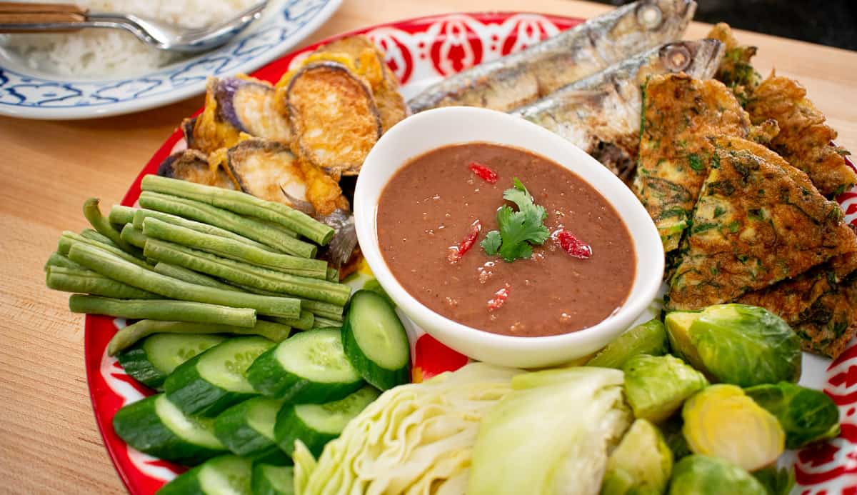 A platter of shrimp paste dip with fresh veggies, omelette, and mackerel.