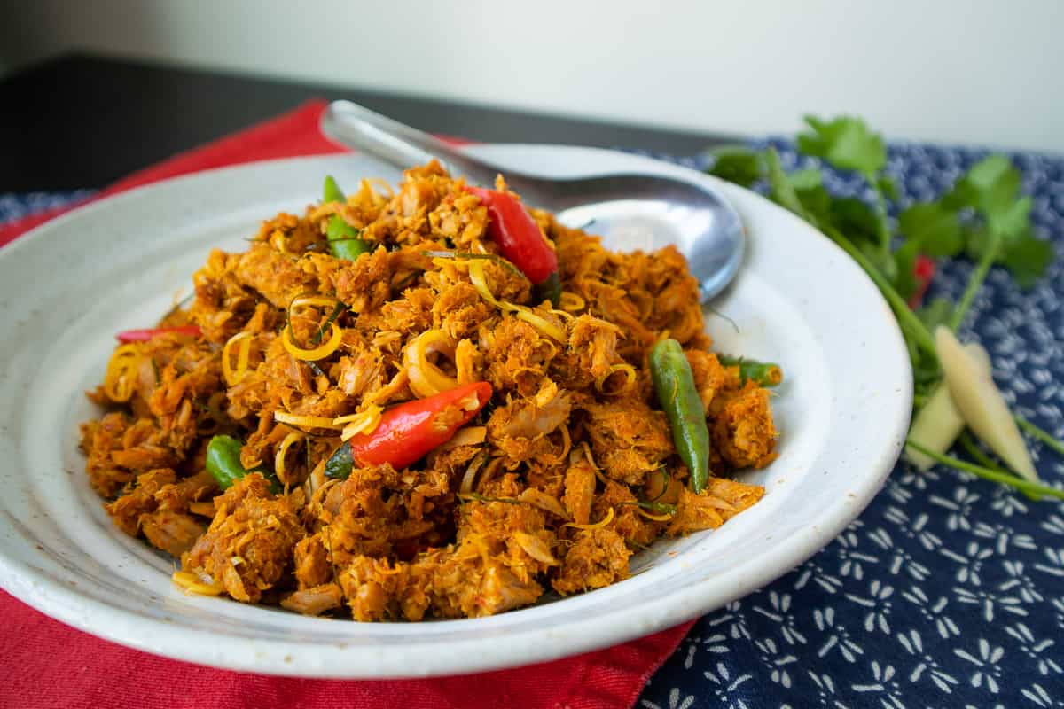 A plate of tuna stir fried in red curry with red and green chilies.