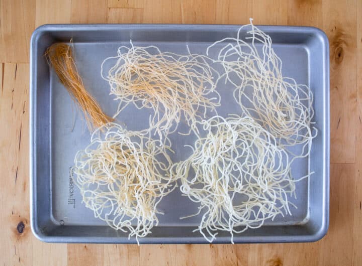 Rice noodles fried at 5 different temperatures on a baking sheet.