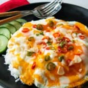 a plate of marbled eggs on rice with a side of cucumber and chilies and garlic on top. With text overlay "Marble Eggs"