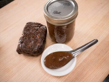 tamarind pulp block, tamarind paste in a jar, and tamarind paste in a spoon