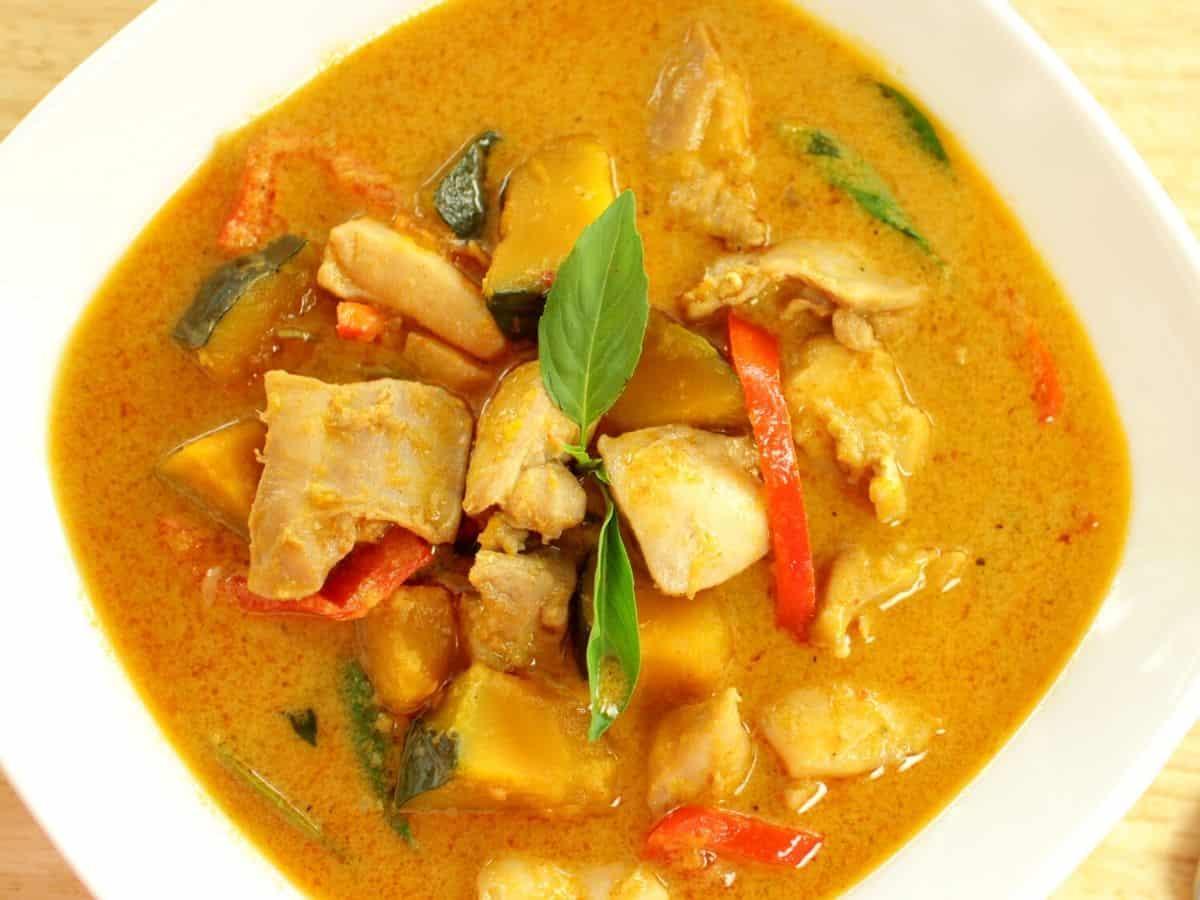 A bowl of red curry chicken with squash