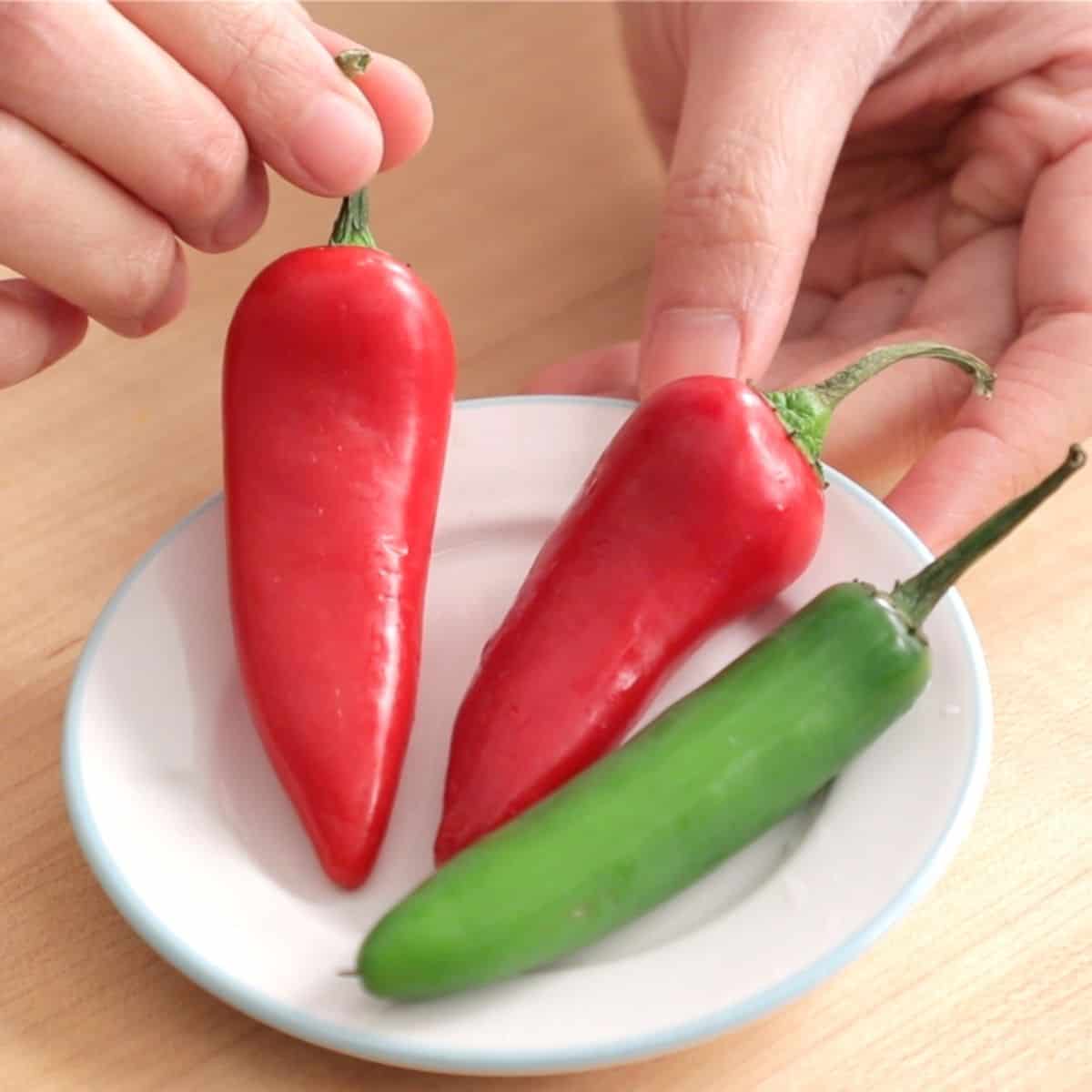 a plate of fresno and serrano chilies