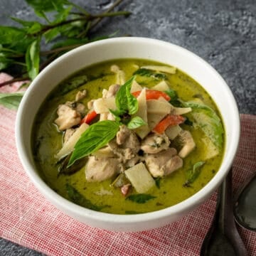 a bowl of thai green curry with basil garnish