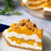 A slice of mango royale on a plate, with the whole pie in the background, with text overlay "Mango Royale"
