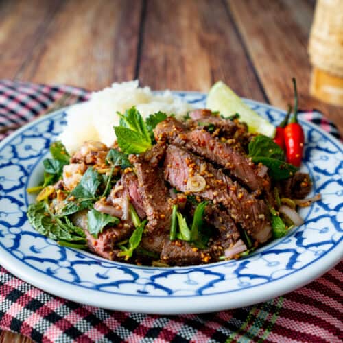 A plate of Thai grilled steak salad with sticky rice - nam tok neua