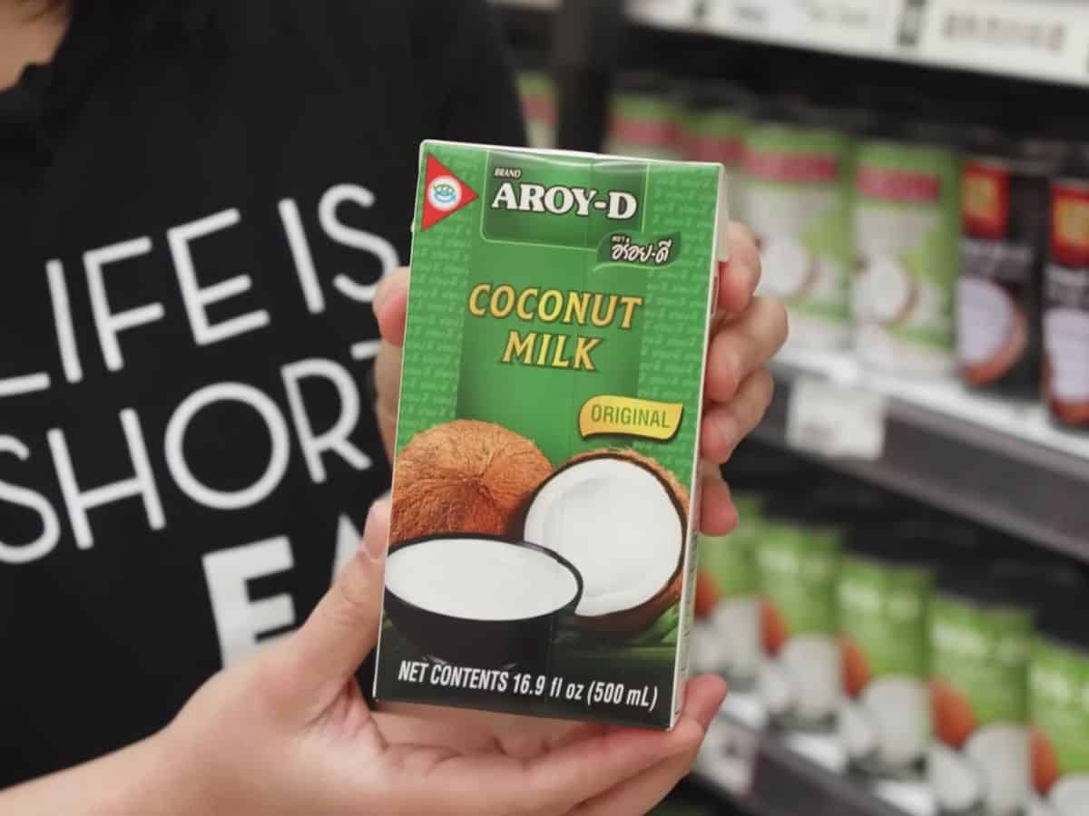 a carton of Aroy D coconut milk held in hand