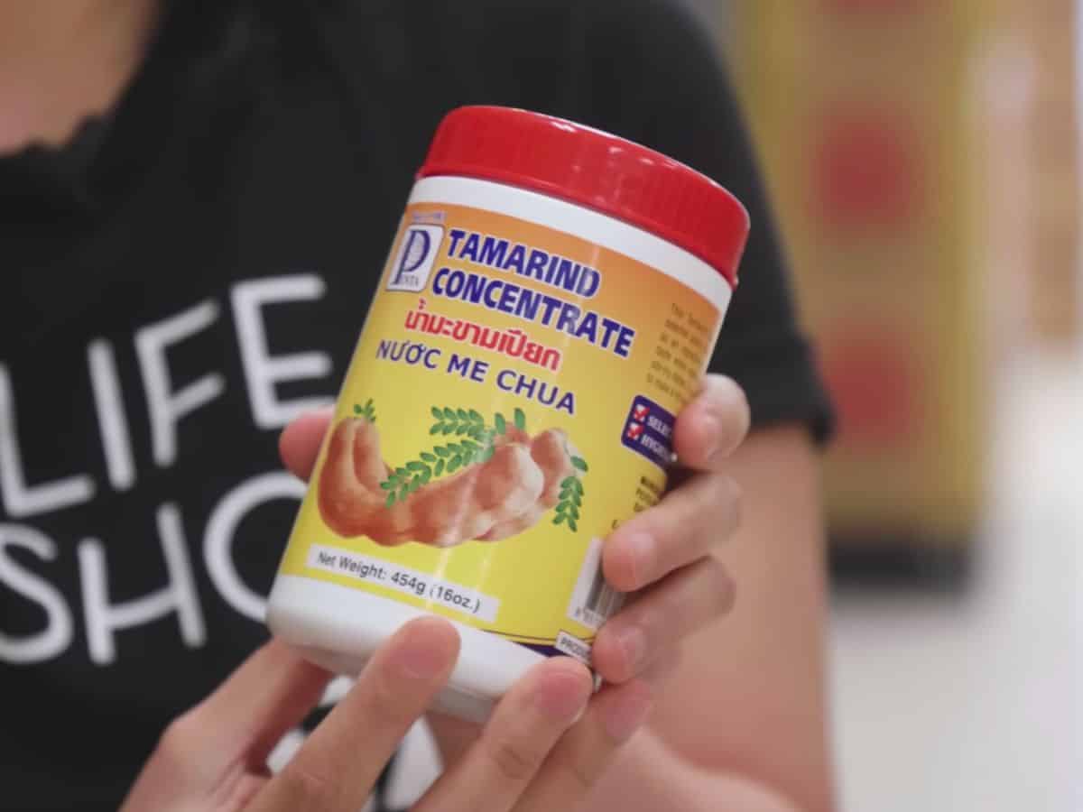a tub of tamarind concentrate held in hand