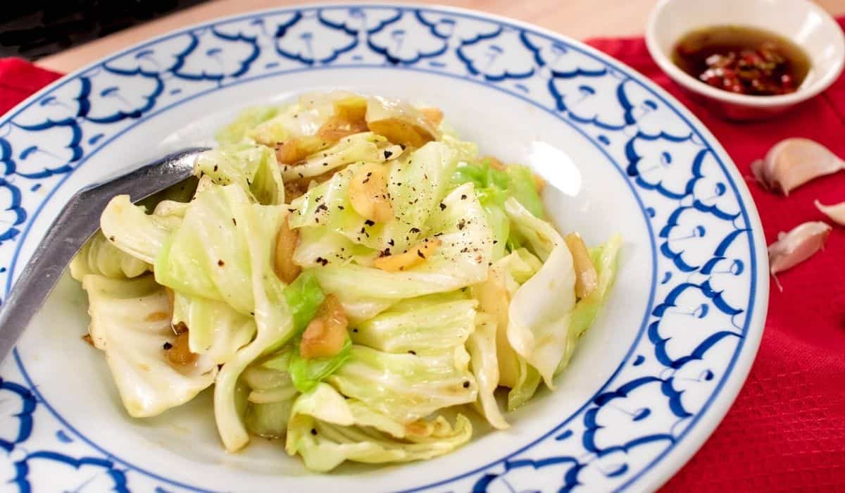 cabbage fish sauce stir fry on a white a blue plate