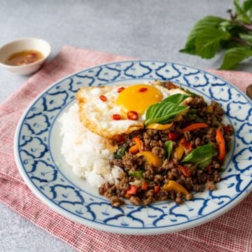 a plate of pad kra pao beef with a fried egg on top