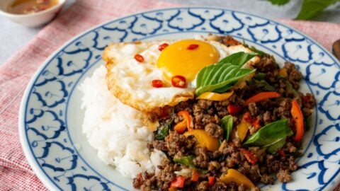 a plate of pad kra pao beef with a fried egg on top