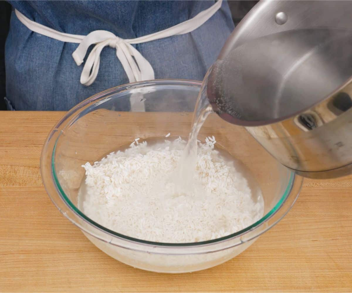 A bowl of sticky rice with hot water being poured in