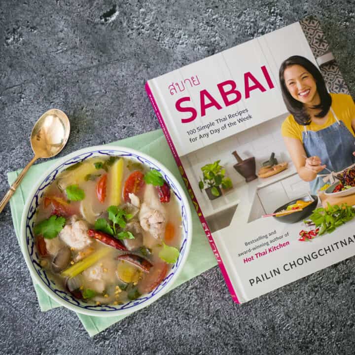 a bowl of chicken wing tom yum beside Sabai cookbook