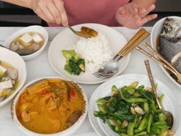 A table of 4 thai dishes - a curry, a soup, a gai lan stir fry