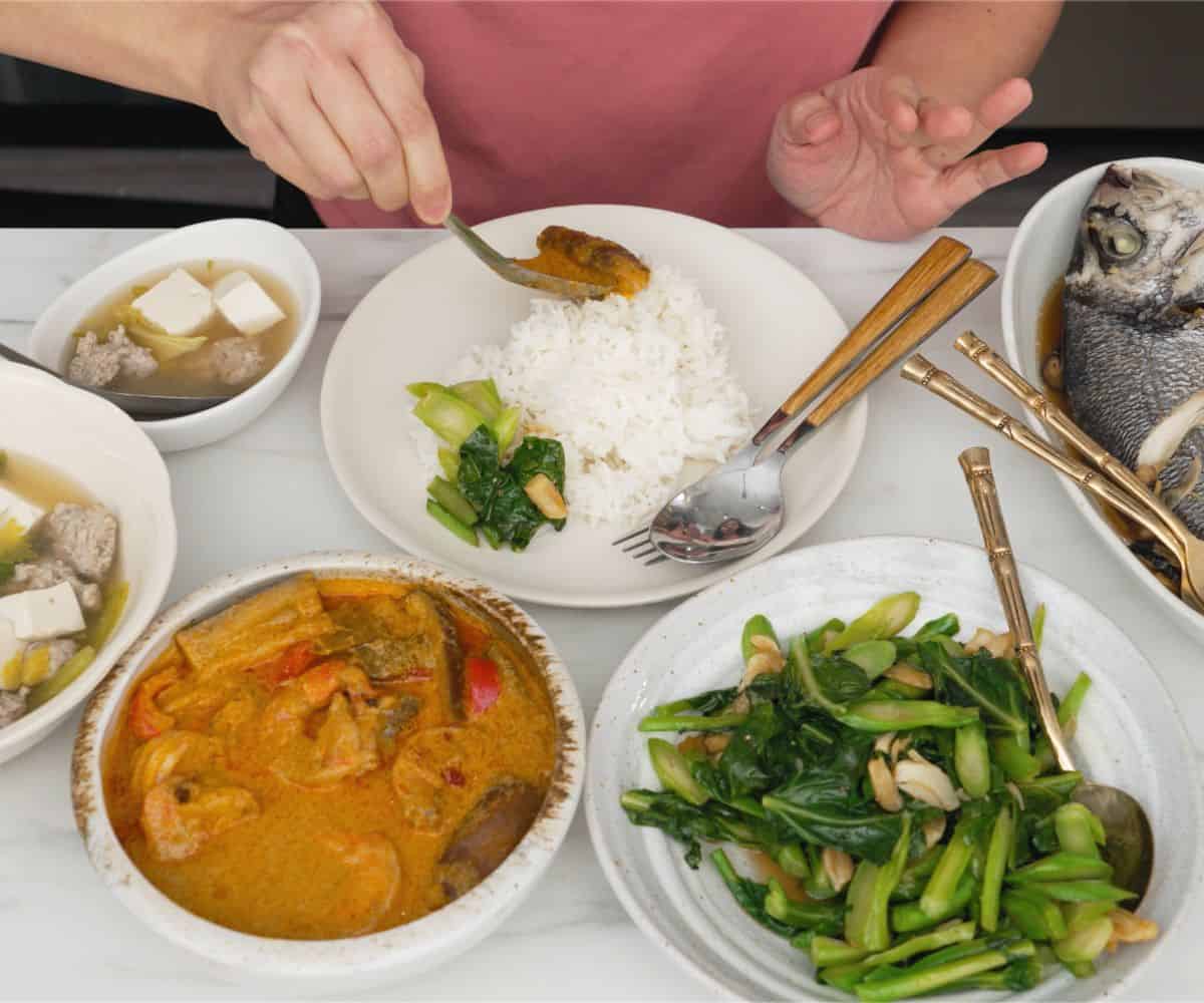 A table of 4 thai dishes - a curry, a soup, a gai lan stir fry