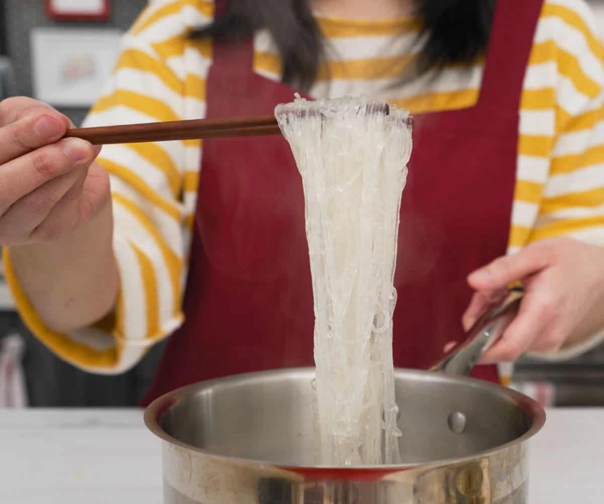 cooked glass noodles held up by chopsticks