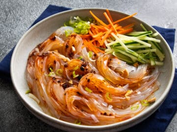 a bowl of glass noodle salad made with mung bean jelly noodles with cucumber and carrots.