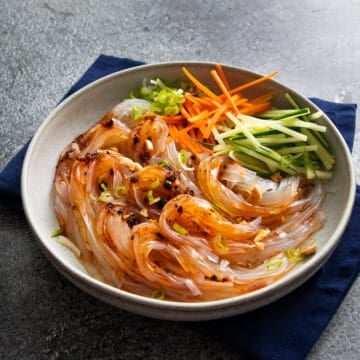a bowl of glass noodle salad made with mung bean jelly noodles with cucumber and carrots.