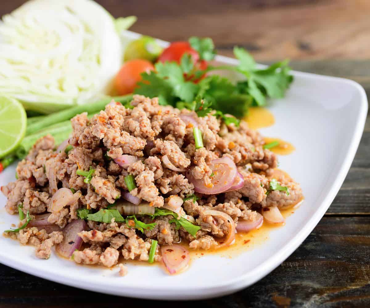 A plate of laab moo with a side of vegetables