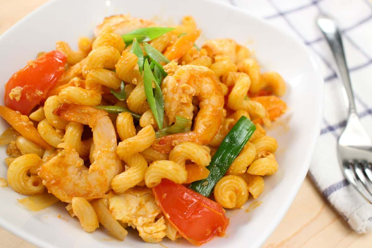 a plate of pad macaroni with shrimp and tomatoes