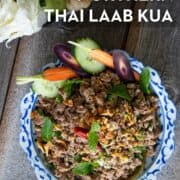 laab kua on a plate with a side of fresh veggies. Text overlay "northern thai laab kua"