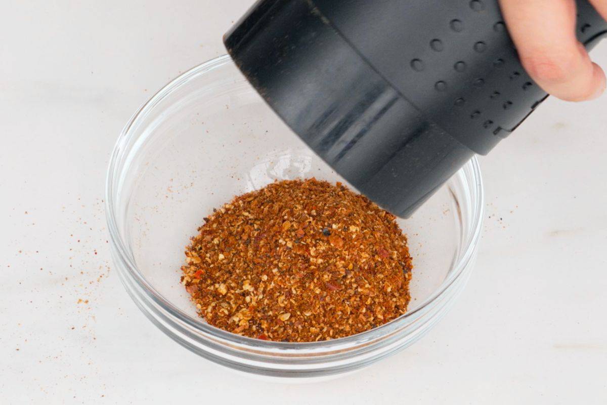 roasted chili flakes being poured from grinder
