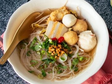 A bowl of noodle soup with fish cakes