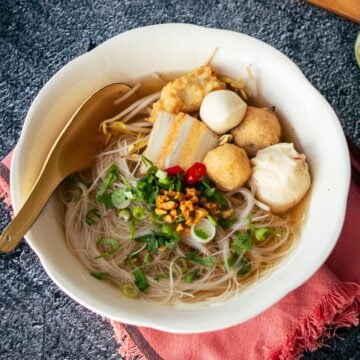 A bowl of noodle soup with fish cakes