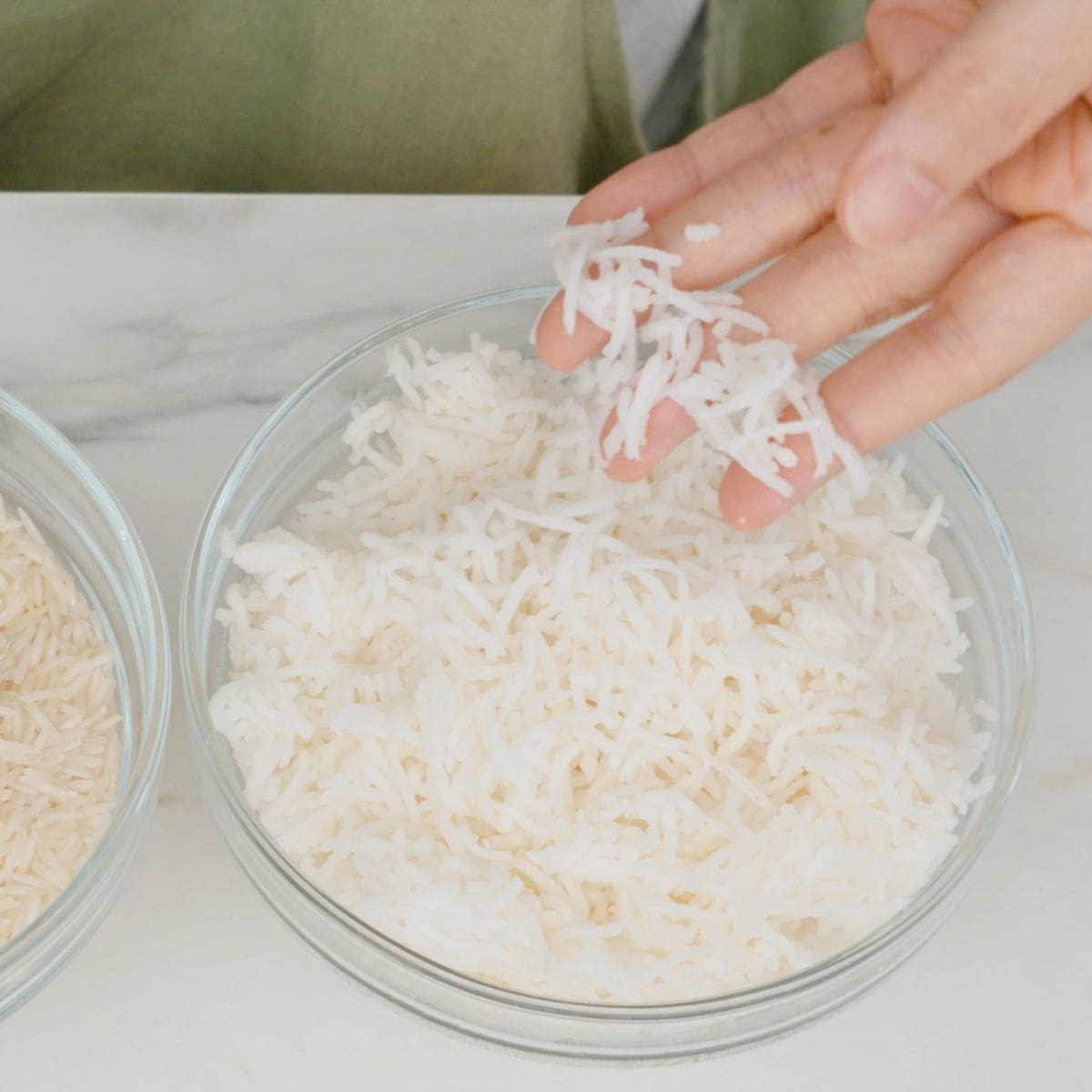 a bowl of basmati rice being picked up by fingers