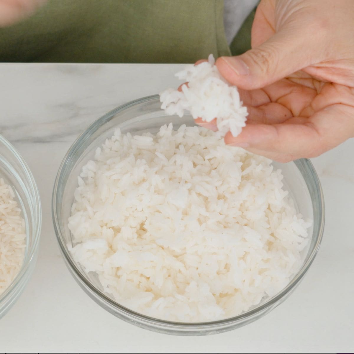 a bowl of jasmine rice being picked up by fingers